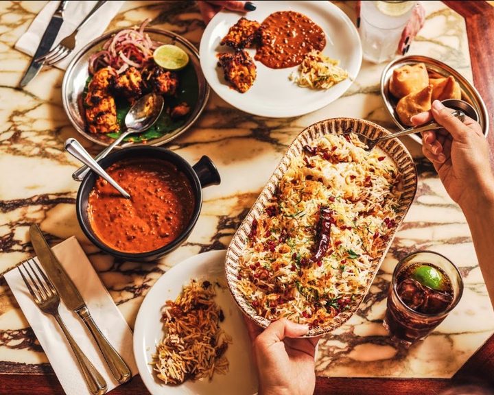 Indian dishes served across a table at Dishoom Kensington