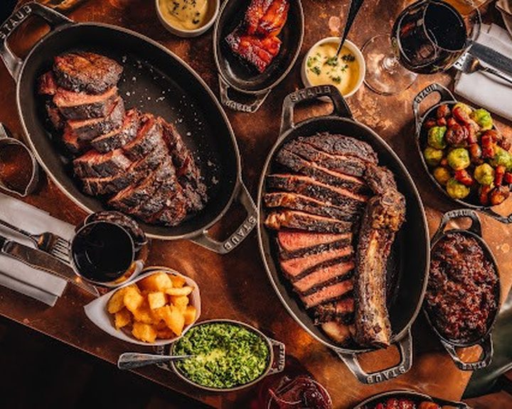 Charcoal-grilled steak with sides at Hawksmoor Guildhall