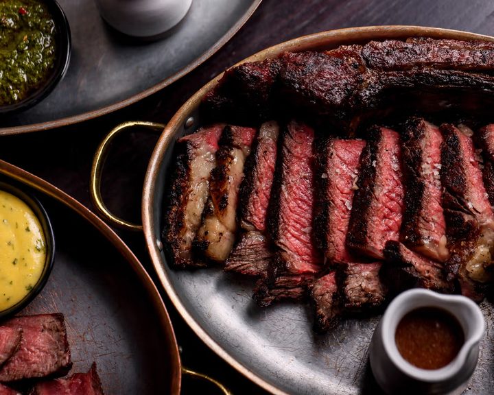 Sliced fire-cooked steak in a pan at Pasture Cardiff