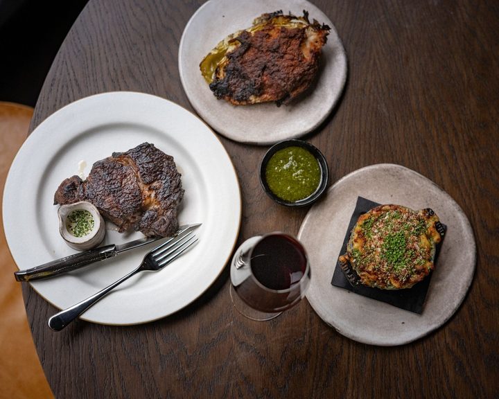 Charcoal-grilled steak with vegetables and side dishes at Pasture Cardiff
