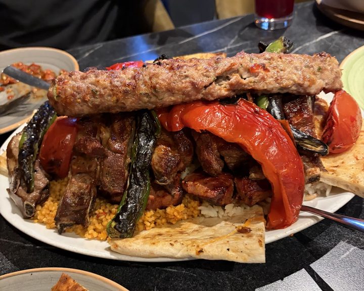 Mixed charcoal-grilled kebabs, peppers and tomatoes at Hala