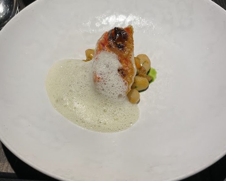 A finely plated fish course with a light foam at Heaneys in Pontcanna