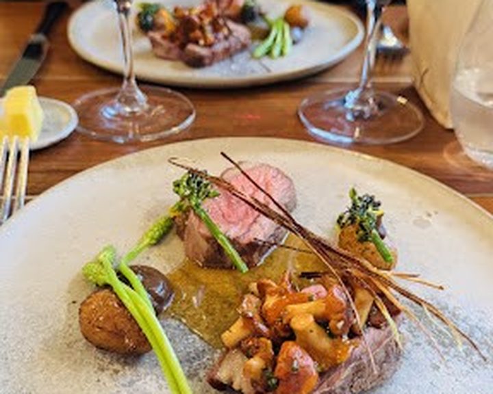Seasonal meat, vegetables and sauce on a tasting-menu plate at OX Belfast