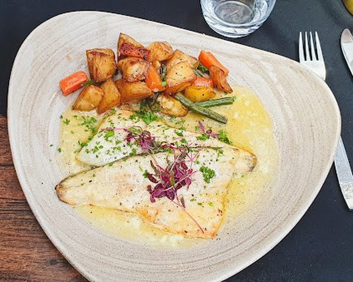 Fish with vegetables and sauce at Elgano Italian Restaurant in Cardiff