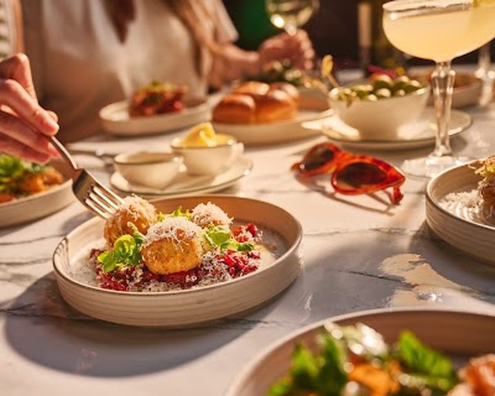 Small plates and mains on a table at Cosy Club Cardiff Bay
