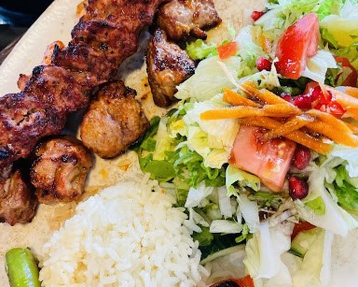 Charcoal-grilled chicken kebab with rice and salad at Midpoint Restaurant