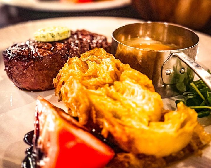 Grilled steak with onion loaf and vegetables at Miller and Carter Muswell Hill