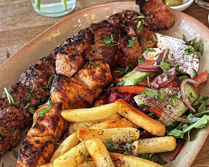 Charcoal-grilled chicken and lamb skewers with salad and chips at Petek