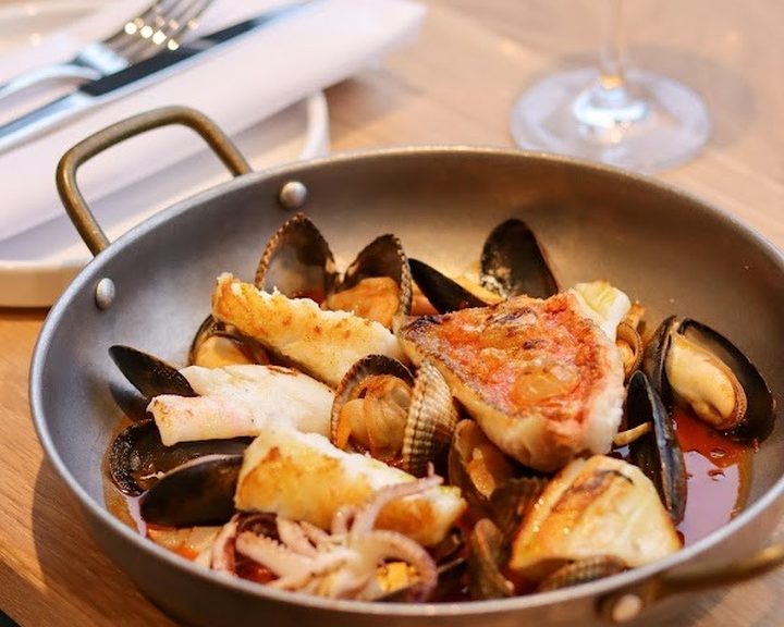 A pan of shellfish and fish in tomato broth at ember at No. 5 in Pontcanna