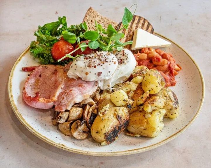 Colourful Edinburgh brunch plate with eggs, bacon, mushrooms and potatoes