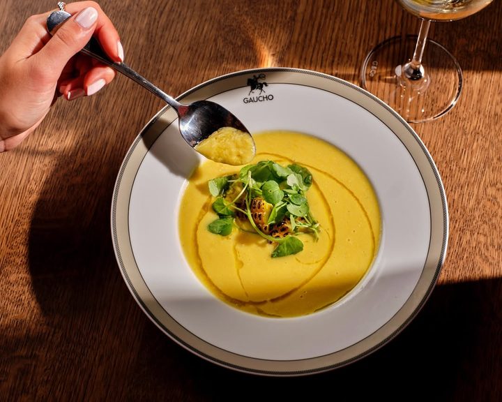 Gaucho autumn soup served with herbs and grilled corn