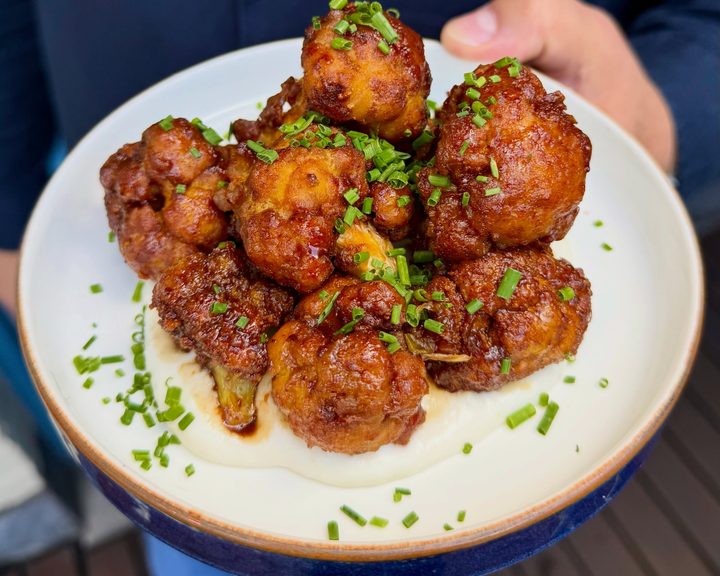 Crispy cauliflower with pomegranate glaze and toum at Imad’s Syrian Kitchen