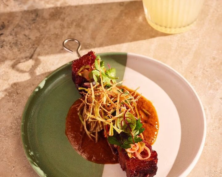 Pork belly skewer with sauce and crisp garnish from Wahaca